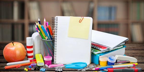 stationary items and an apple on a table