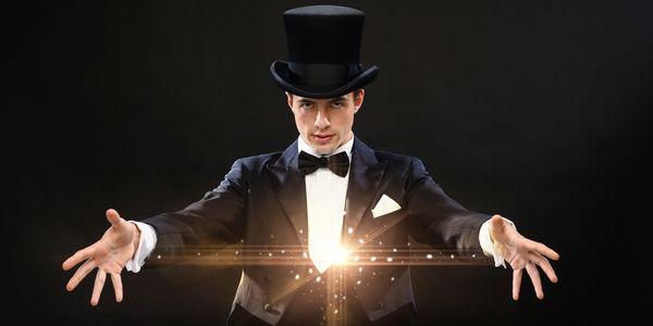 Magician in a top hat performing a dazzling magic trick with glowing light effects.