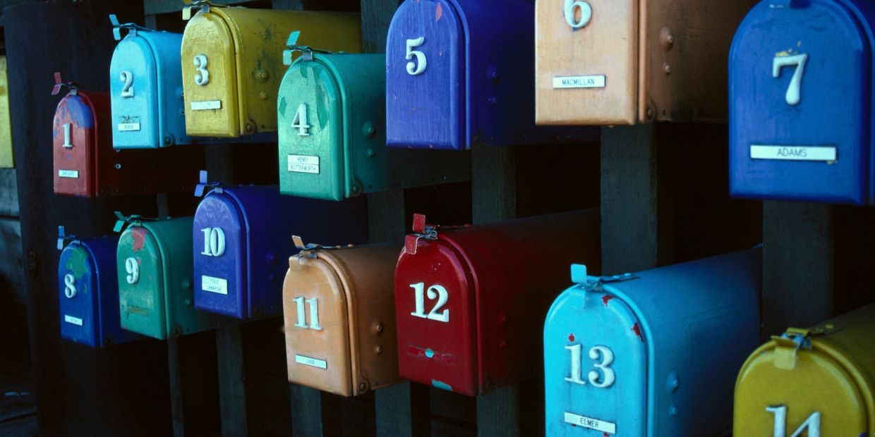 A row of colorful numbered mailboxes lined up outdoors.