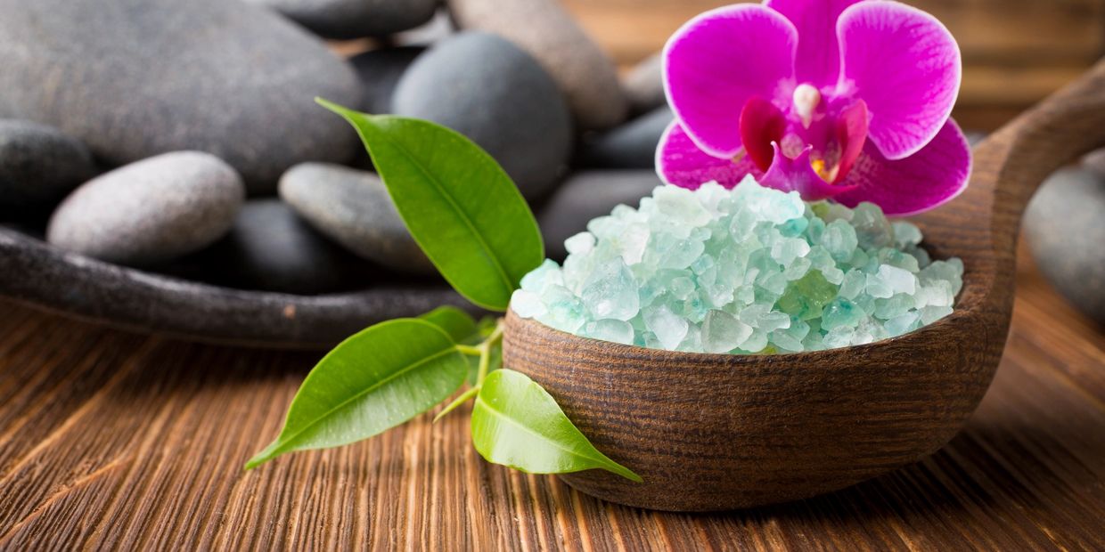 A relaxing image of healing stones, an orchid, and bath salts