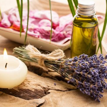 A candle with lavender and essential oils on a table