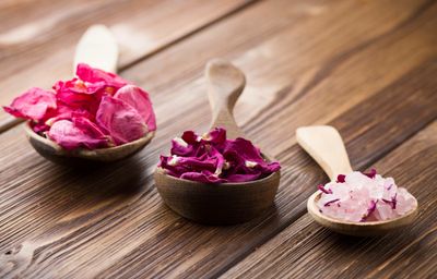 Three wooden spoons with pink flower blossoms and salt chrystals