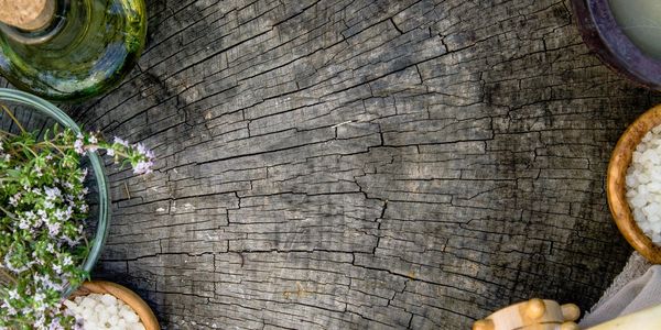 Herbs, olive oil, and salt on a rustic wooden surface.
