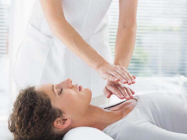 a professional performing reiki on a patient.
