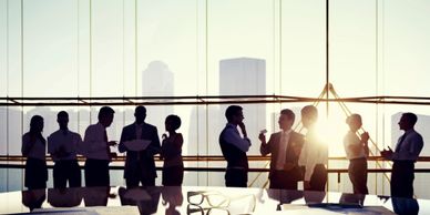 Group of professionals networking in an office at sunset