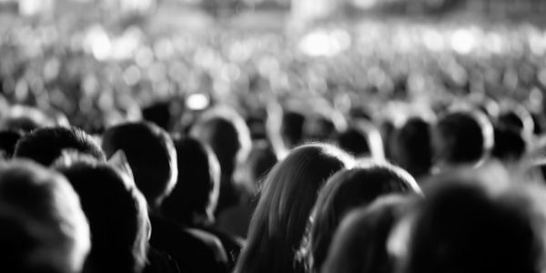 A large crowd viewed from behind in black and white.
