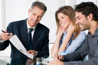 Man in suit showing man and woman a paper with a pie chart