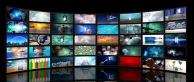 Multiple screens displaying diverse digital and nature images in a curved setup.