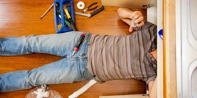 Plumber working under sink