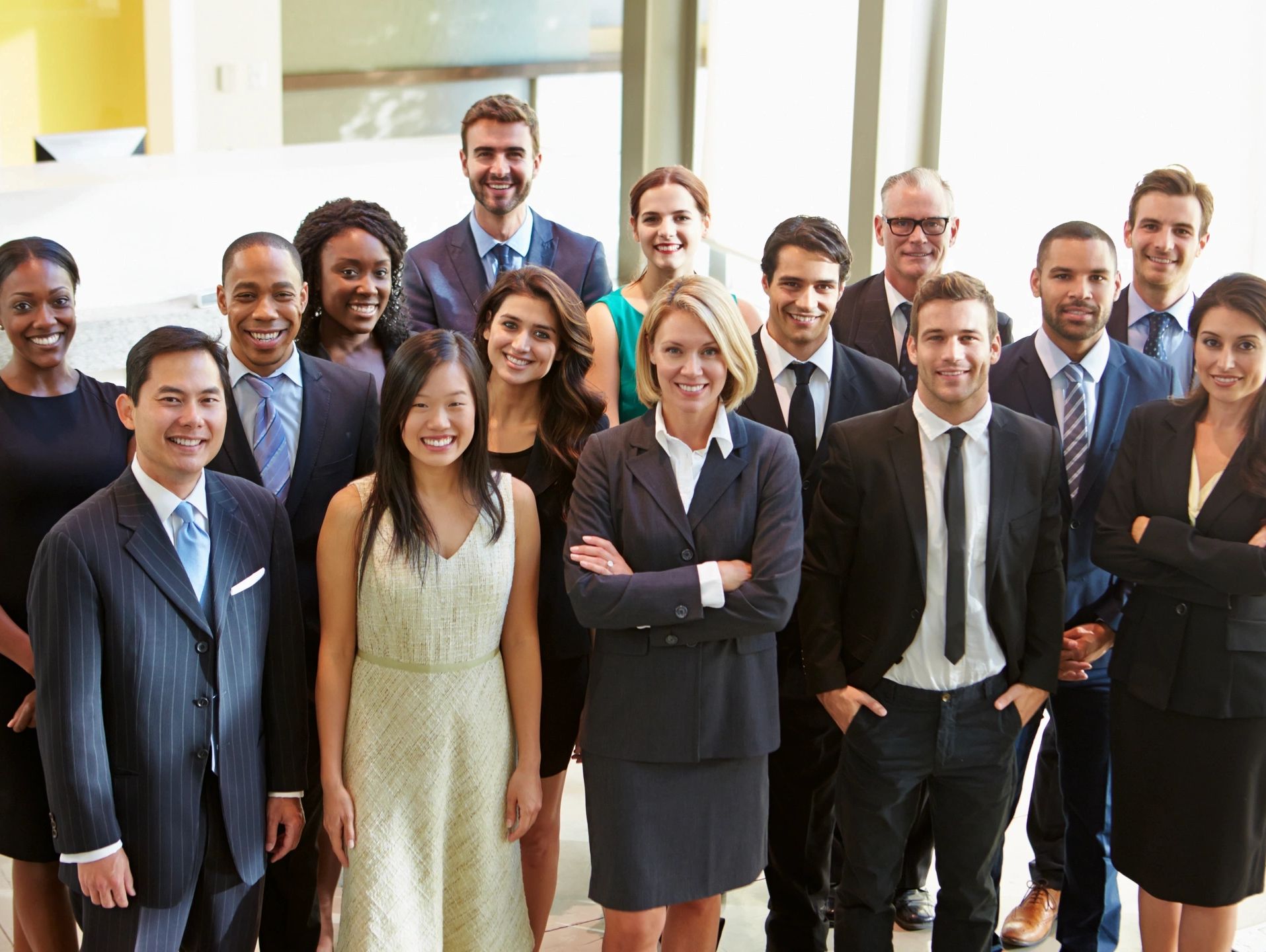 Diverse group of business professionals smiling and posing confidently.