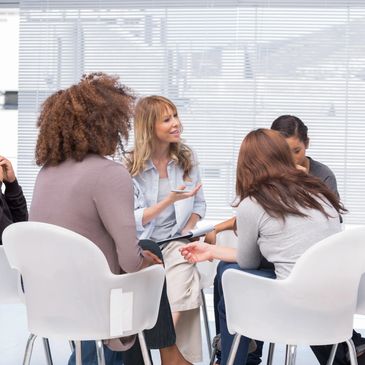 six people seated in a circle having a discussion