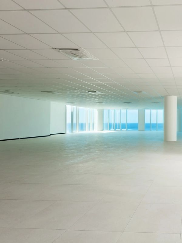 Spacious empty room with large windows overlooking the ocean.