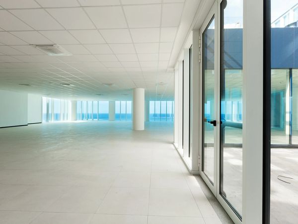 Spacious empty room with large windows and ocean view.