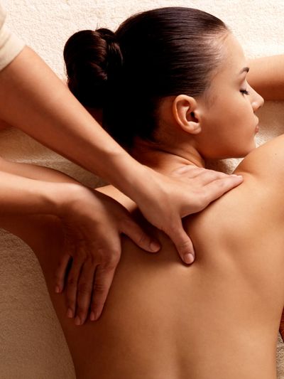 Woman receiving a relaxing back massage in a spa setting.