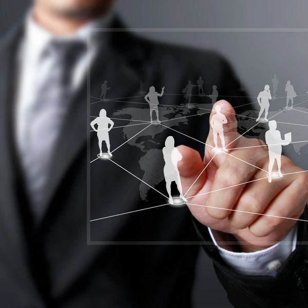 Businessman interacting with a virtual network of connected people icons.