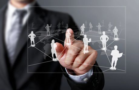 Businessman interacting with a virtual network of people icons.