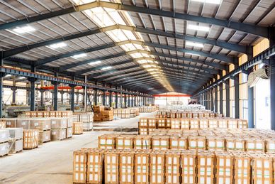 Large warehouse filled with stacked wooden crates under a high ceiling.