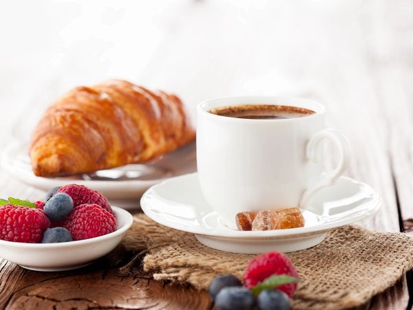 Coffee, croissant, and fresh berries.
