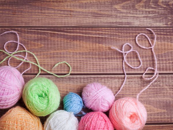 Colorful yarn balls arranged on a wooden surface.