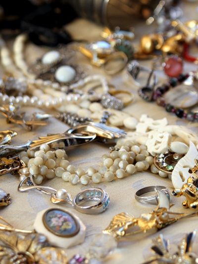 A collection of vintage jewelry including rings and beaded necklaces.