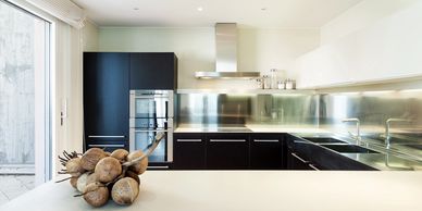 Modern kitchen with black cabinetry and stainless steel appliances.