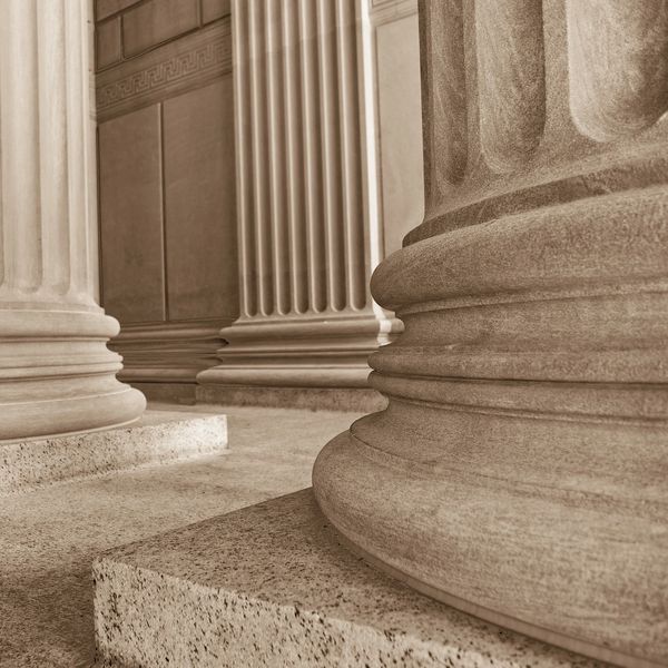 Close-up of classical stone columns with fluted designs and ornate bases.