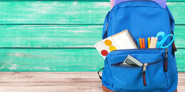 backpack filled with school supplies on colorful bench
