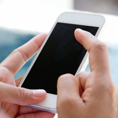 Person holding and interacting with a smartphone.