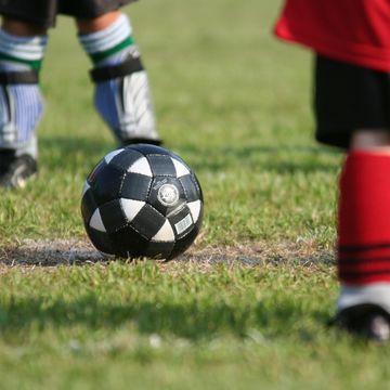 kids on soccer field with soccer ball