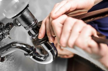 plumber fixing a leaky pipe