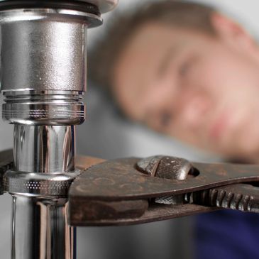 A Plumber Working on a Pipe