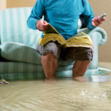 Restoration Worker working in almost knee deep flooding in room