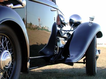 Close-up of a classic black vintage car's side and wheel.