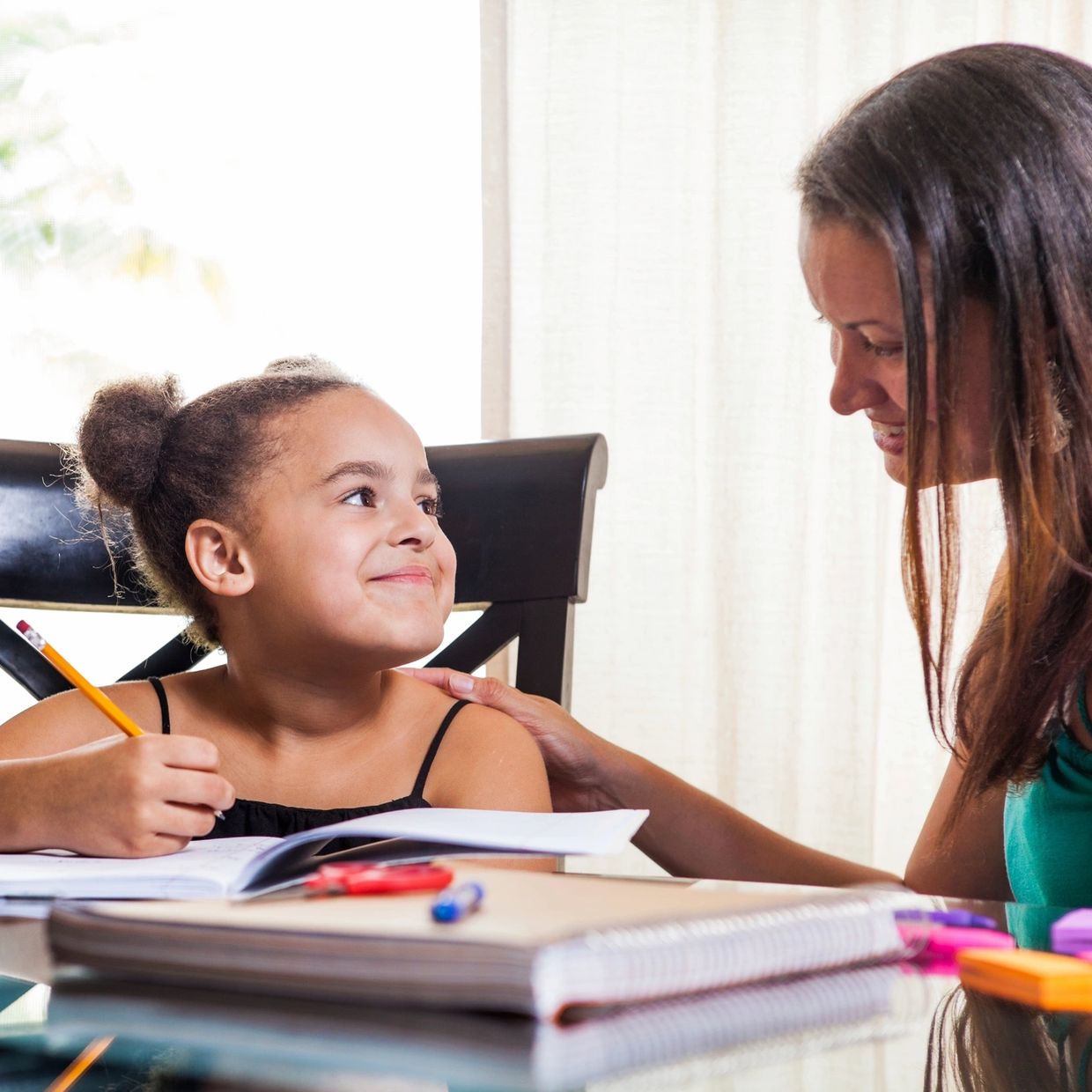 Girl studying with mom's support.
