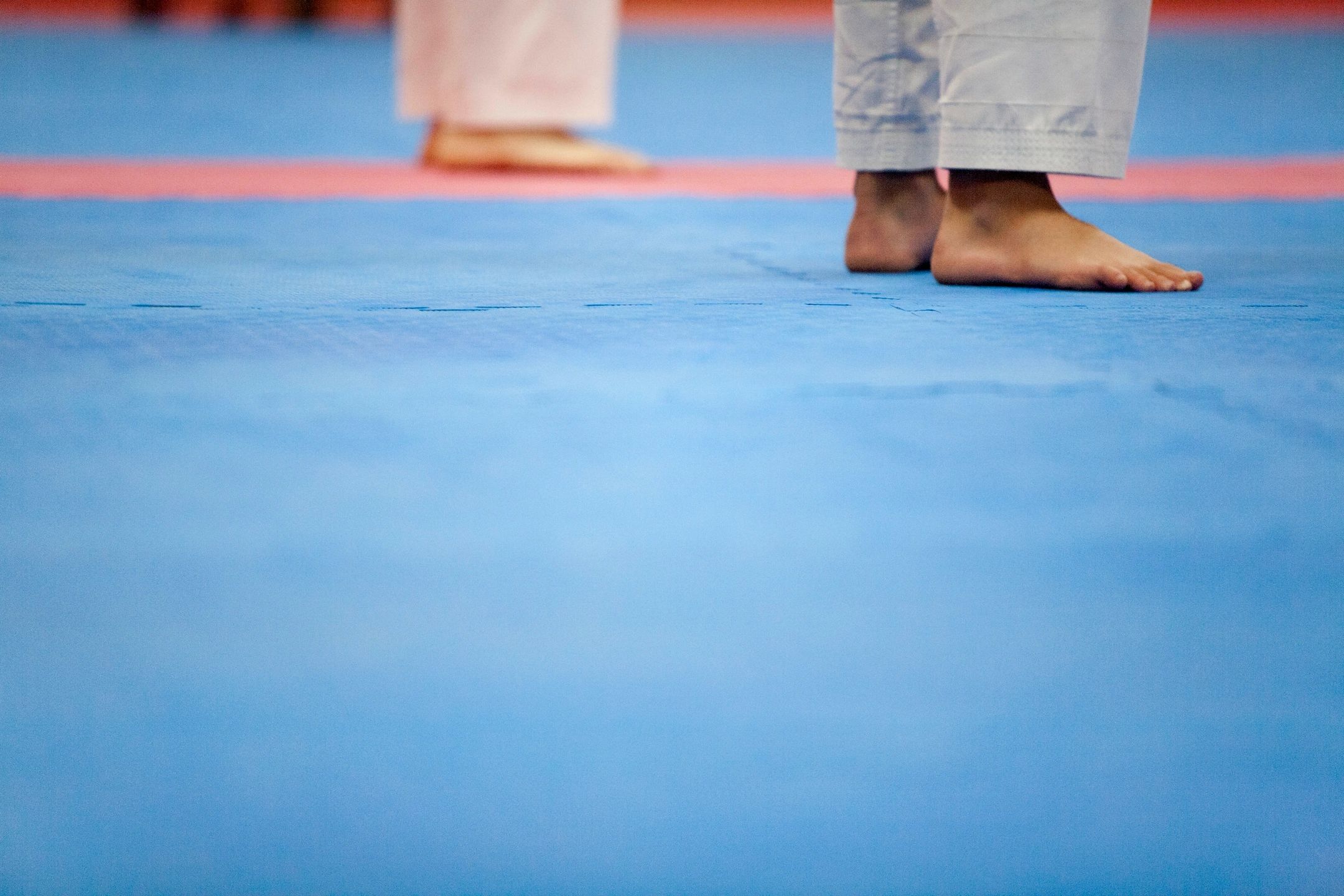 Close-up of bare feet on a martial arts mat.