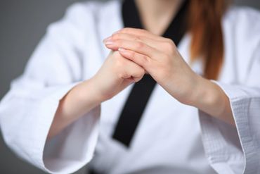 Person in martial arts uniform practicing hand technique.