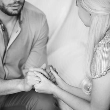 A man holding a girl's hands in a counselor's office