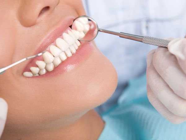 Dentist examining patient with dental insurance which pays for the dental service. US Dental Adviser