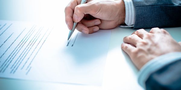 Client signing a document with a pen