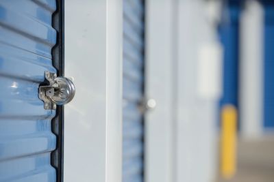Close-up of a padlock on a blue storage unit door.