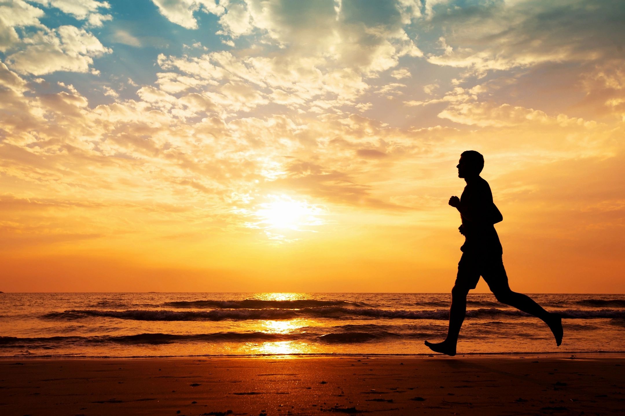 Man running on the beach Manteca CA.  Pain clinic CCPMR