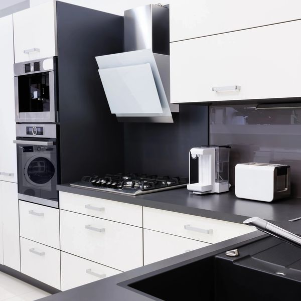 Modern kitchen with black and white cabinetry and appliances.