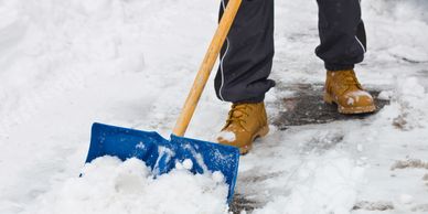 Winter time, snow on the ground and a man shovelling it up