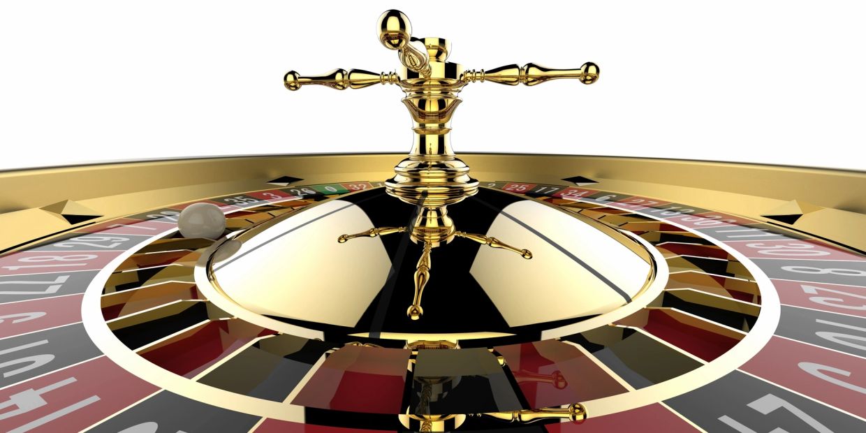 Close-up of a golden roulette wheel with a white ball.