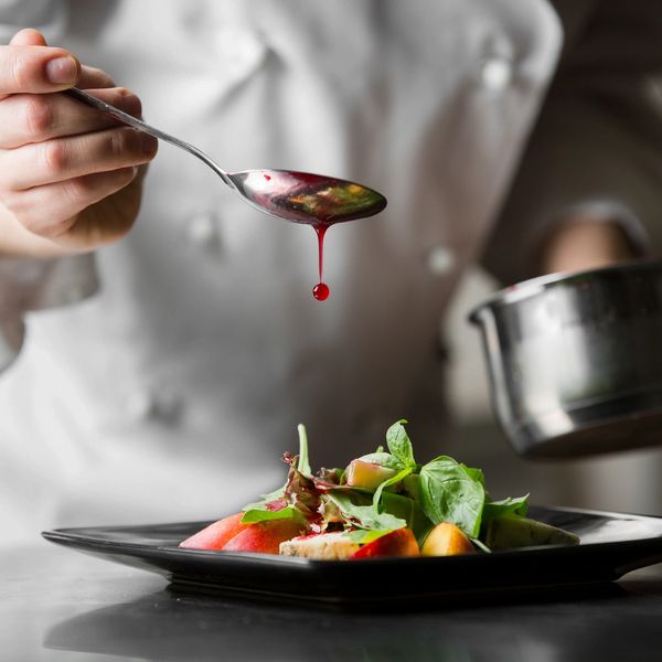 Private chef working on the finishing touches of a plate. 