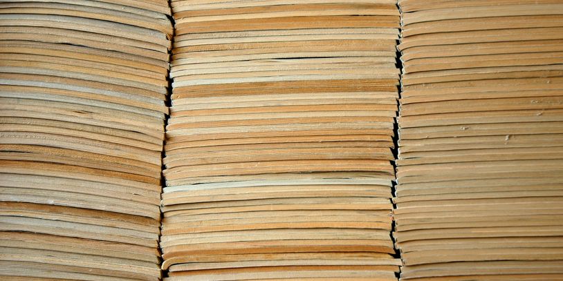 Stacks of old, yellowed paper or book pages tightly packed together.
