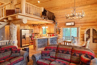 Cozy rustic cabin interior with wooden walls and patterned furniture.
