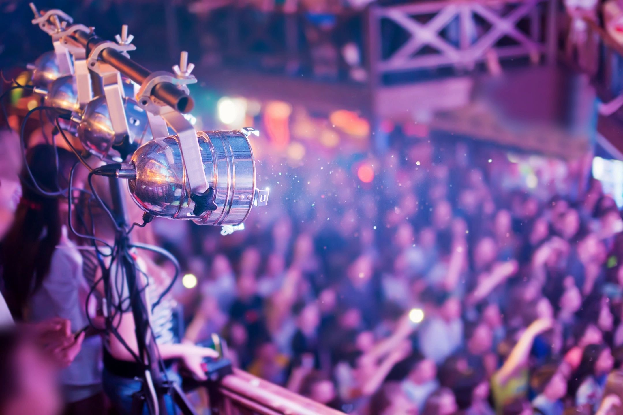 Stage lights illuminating a crowded concert audience.