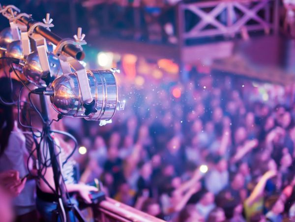 Stage lights illuminating a lively crowd at a concert or event.