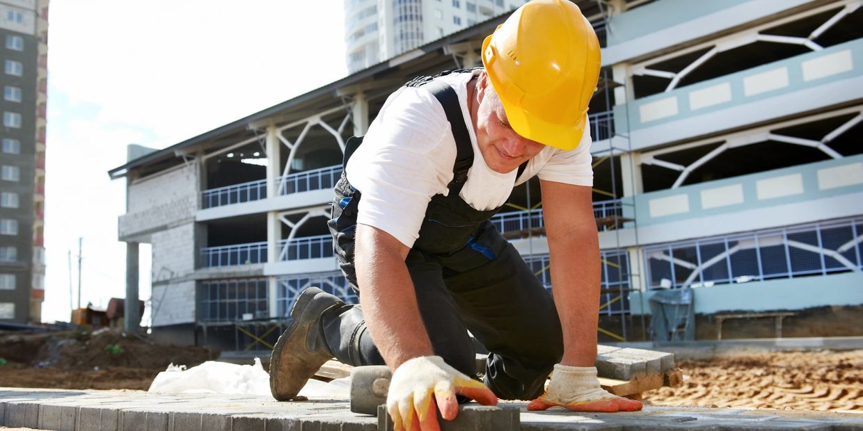 Construction worker laying bricks on site.